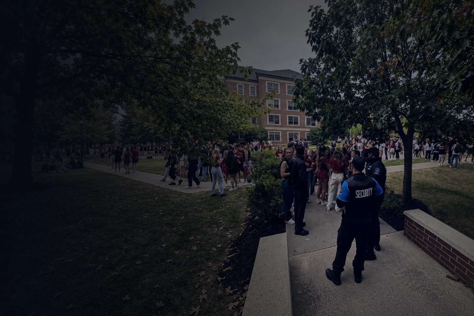 KingsGuard campus security guard standing beside a university walkway.